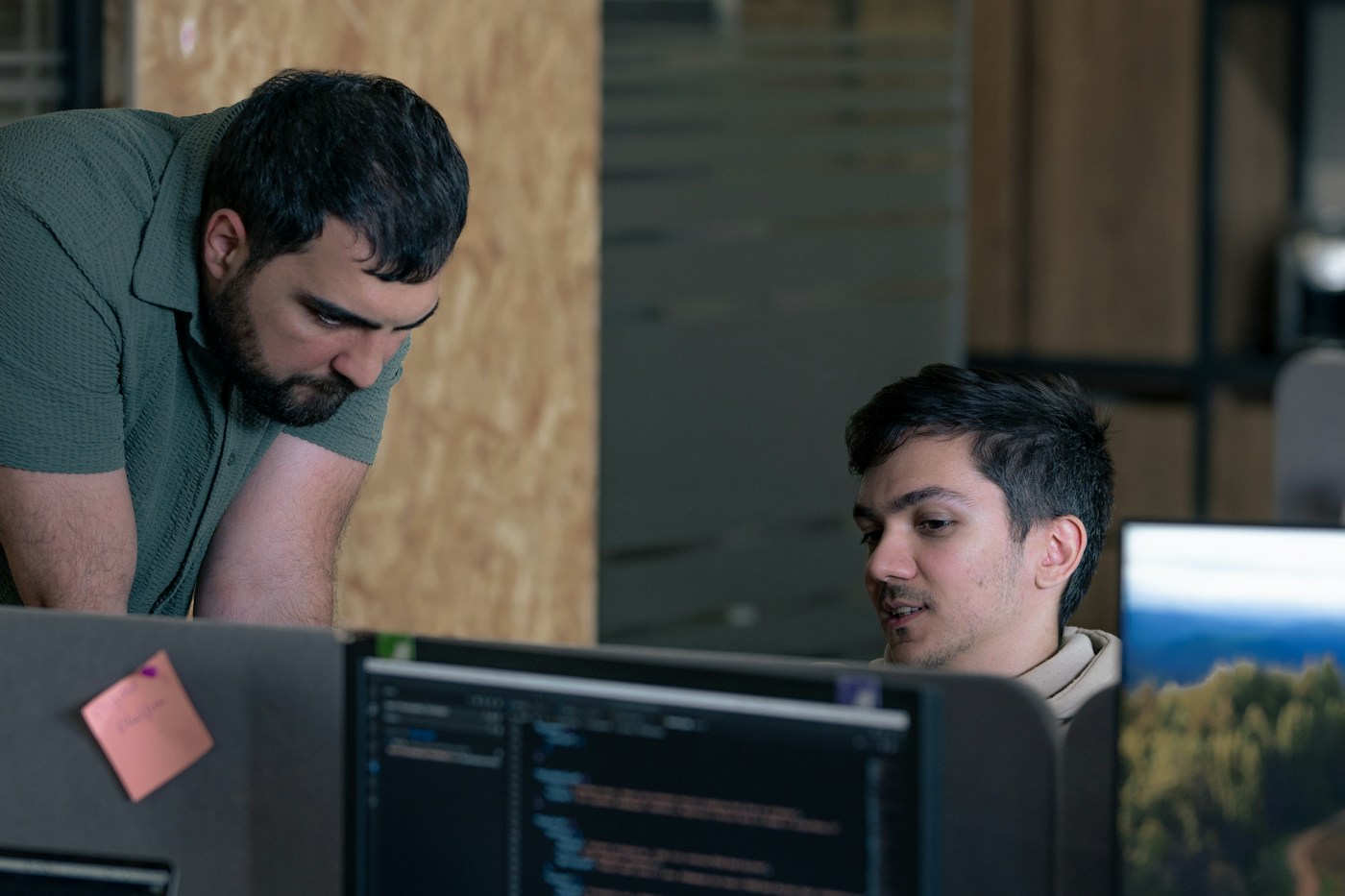 Two developers reviewing work together at computer monitors